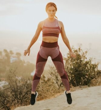 woman jumping above gray sand